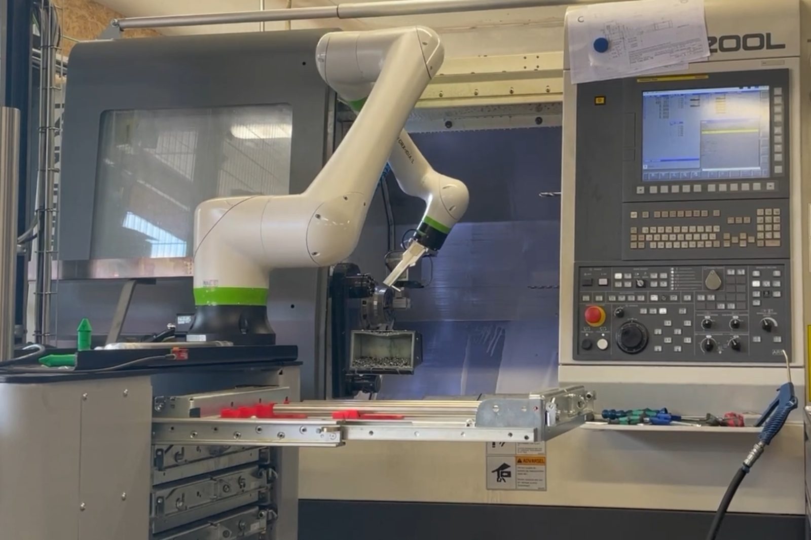 Fanuc CRX-10iA/L collaborative robot loading a CNC lathe at EH St&aring;l, with the lathe control panel alongside
